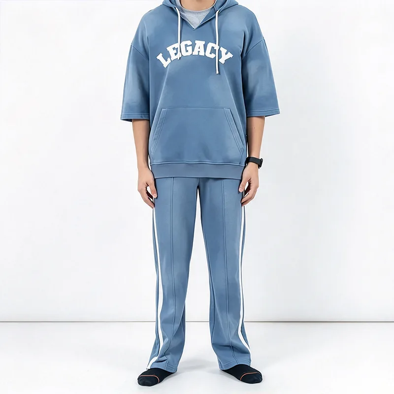 Blauw trainingspak met korte mouwen en capuchon en witte broek met zijstreep